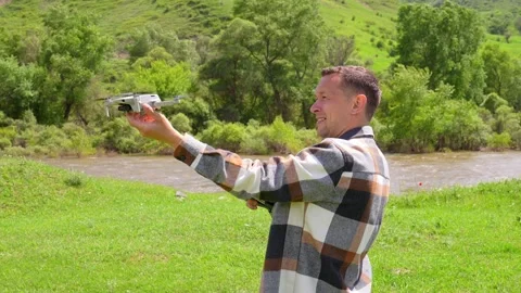 Man launching a quadcopter drone from his hand in nature Stock Footage 340627634