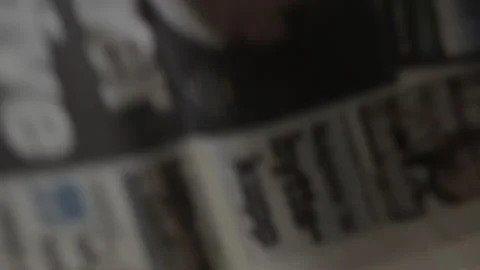 A man lay down a collection of old newspapers from Australia, USA, Germany, Norw Stock Footage 169975930