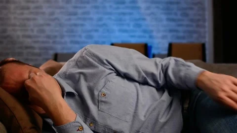 Man lay down on sofa in living room. He rubbing his eye tired from work Video stock 149065389