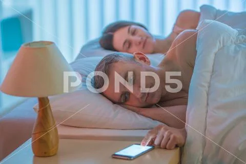 The man lay with woman and phone Stock Photos