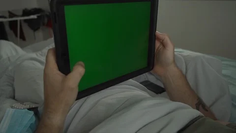Man laying in bed using tablet Chroma key green screen Stock Footage 128294250