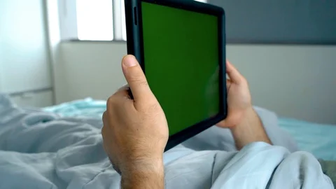 Man laying in bed using tablet Chroma key green screen Stock Footage 128294274