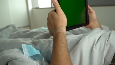 Man laying in bed using tablet Chroma key green screen Stock Footage 128294292