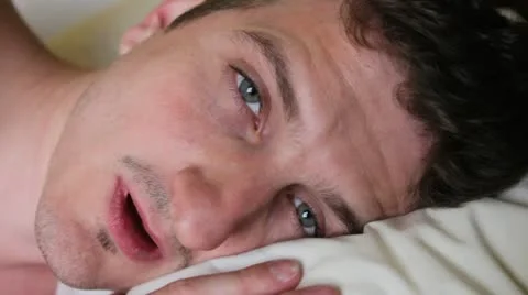 Man laying in bed yawns Stock-Footage 10900906