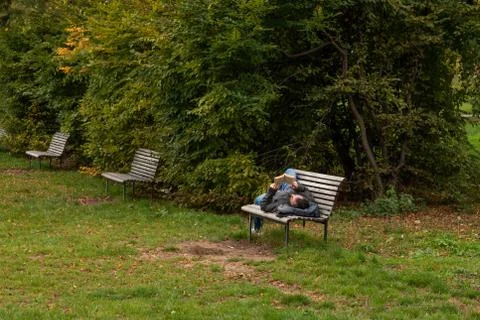 Man is laying on a bench while reading a book on Letna Park in Autumn 2020 on Stock Photos