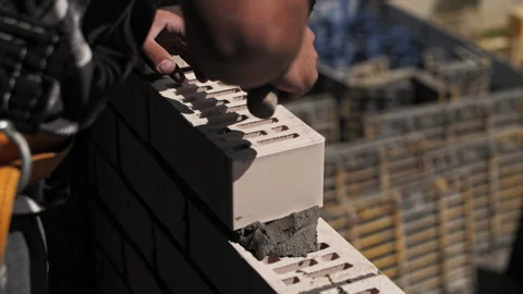 Man laying bricks at a construction site close-up Stock Footage 245008986