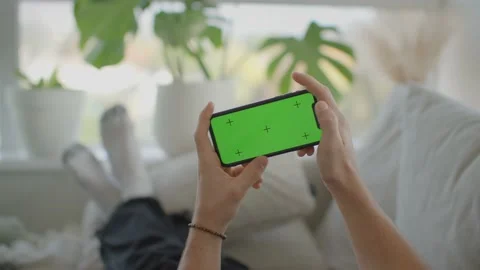 Man laying on couch, playing game on iphone, mockup, green screen 库存影片 218466967