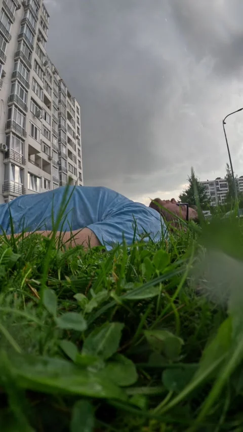 Man laying down in grass under the rain Stock Footage 251709464
