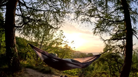 Man laying down hammock looking on sunset Stock Footage 255202913
