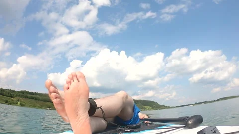 Man laying down on supboard sunbathing Stock Footage 246525536