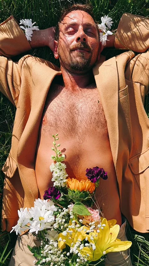 Man laying in grass, grass, field, flowers, floral, portrait of a man relaxing, Stock Footage 247204816