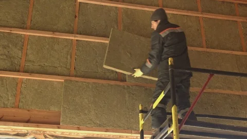 Man laying insulation at height Stock Footage 125099774