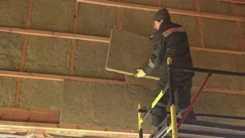 Man laying insulation at height Stock Footage 198432427