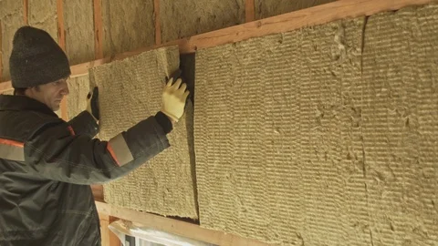 Man laying insulation in a wall Stock Footage 125105980