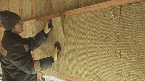 Man laying insulation in a wall Stock Footage 198432482