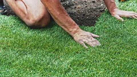 Man Laying Out Rolls Of Sod. Making A Green Grass Lawn. SLOW MOTION. Stock Footage 140294556