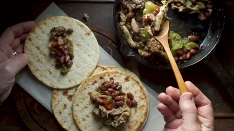 Man is laying a ready-made chicken with pepper on the tortilla. Video Stock Footage 85980169