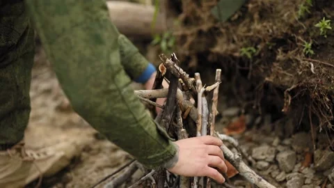 Man lays the branches for the fire together Video stock 93540148