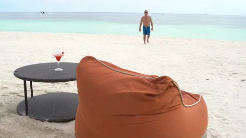 A man lays down on a deck chair and drinks cocktail Stock Footage 91322505