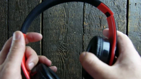 Man lays down wireless headphones on wooden background Stock Footage 106934419