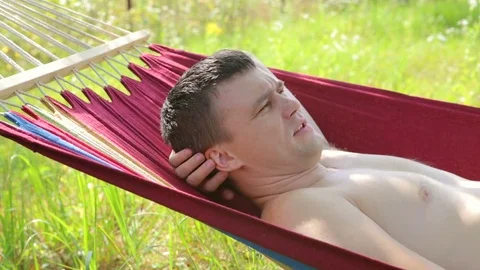 A man lays on a hammock Stock Footage 80996829