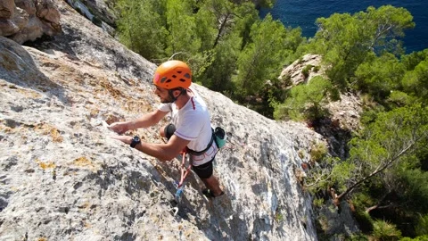 Man lead climbing in wall next to sea 4K 17 Stock Footage 139982528