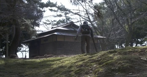 Man with Leaf Blower next to Temple Stock Footage 73153255
