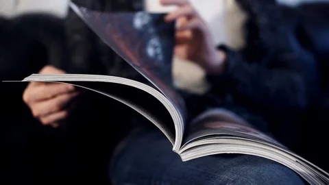 Man leafing through a glossy magazine Stock Footage 71500837