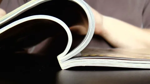 Man leafing through a magazine Stock Footage 79539950