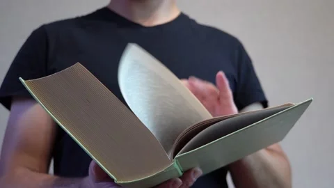 Man leafing through the pages of a book 4K Video stock 205569270