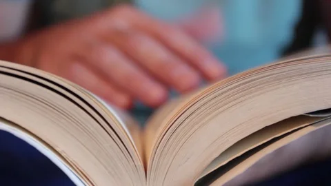 A man leafs through a page of a book while reading Stock Footage 116261815