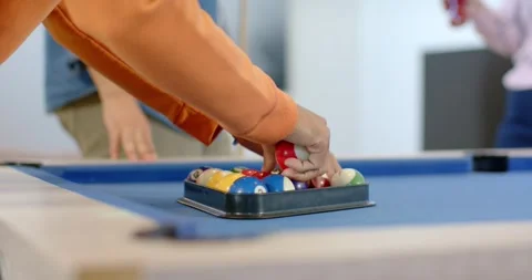 Man leaning over blue pool table placing rack adjusting billiard balls for break Stock Footage 341320175
