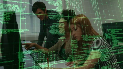 Man leaning over monitors initiating debugging on code while women typing and Stock Footage 312360731