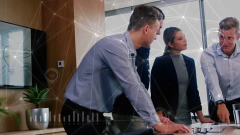 Man leaning over table leading while colleague pointing at laptop and team Stock Footage 335317511