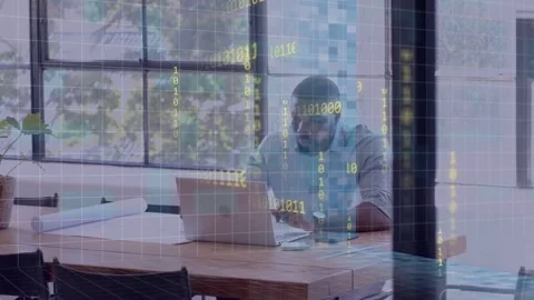 Man leaning typing laptop in office entering data checking phone plans binary Stock Footage 334883872