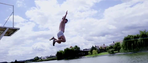 Man leaping off an elevated platform or diving board Video stock 203800556