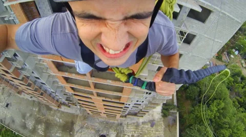 Man leaps forward, holding the rope and closing his eyes in fear Stock Footage 48361251