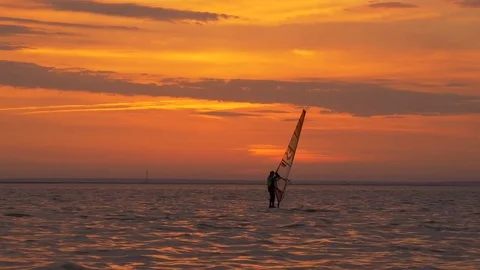 Man learning how to windsurf at sunset Stock Footage 77191566