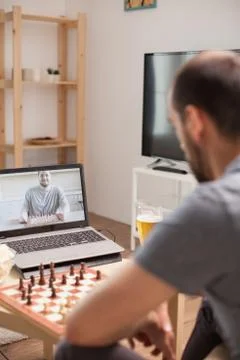 Man learning to play chess on a video call Foto stock