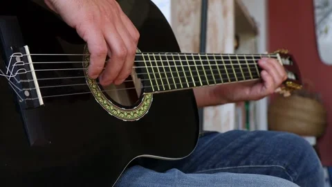 A man is learning to play the guitar. Close-up. Video stock 244878126