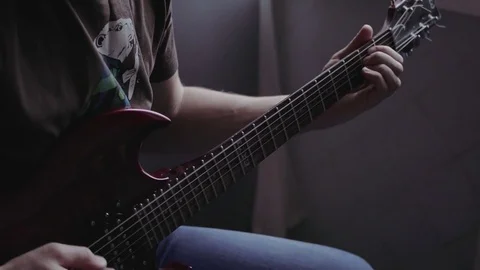 A man learns to play the guitar on the kitchen Video stock 82911475