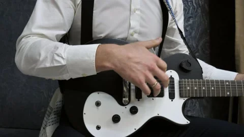 Man learns to play the guitar. Strumming on an acoustic guitar Stock Footage 226381628