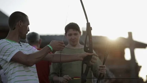 Man learns to shoot an from the bow Stock Footage 82365430