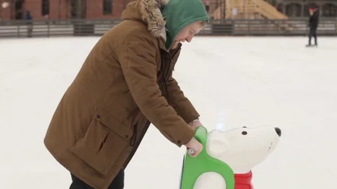 Man Learns to Skate With a Bear Skates on Ice Rink Stock Footage 73655291