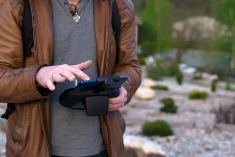 A man, in a leather jacket controls the device from the remote control Stock Photos