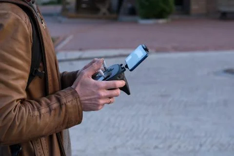 A man, in a leather jacket controls the device from the remote control Stock Photos