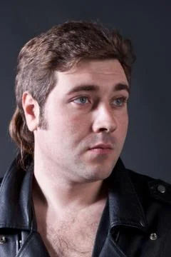 Man in a leather jacket on a gray background shot in studio Stock Photos
