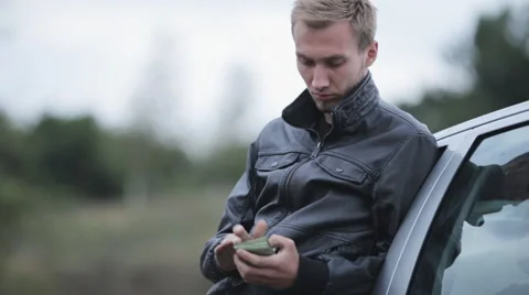 A man in a leather jacket near the machine counts the money Stock Footage 55334890