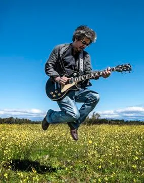 Man in leather jacket playing guitar Stock Photos