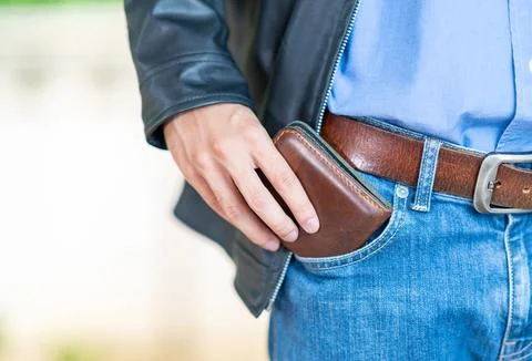 The man in leather jacket pulls a brown leather wallet. Stock-Fotos